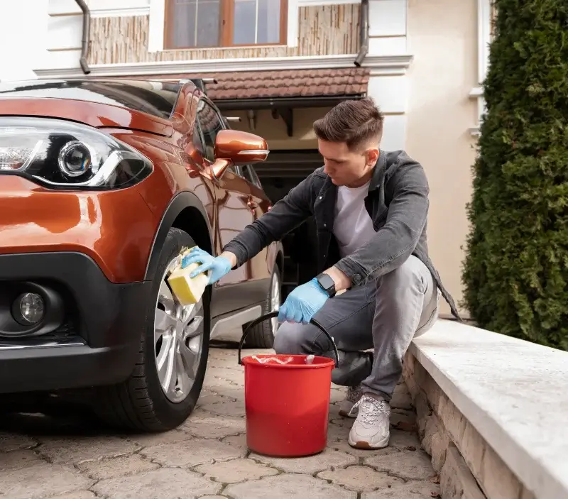 Lavage auto à domicile Teissières-de-Cornet : professionnel intervenant sur un véhicule